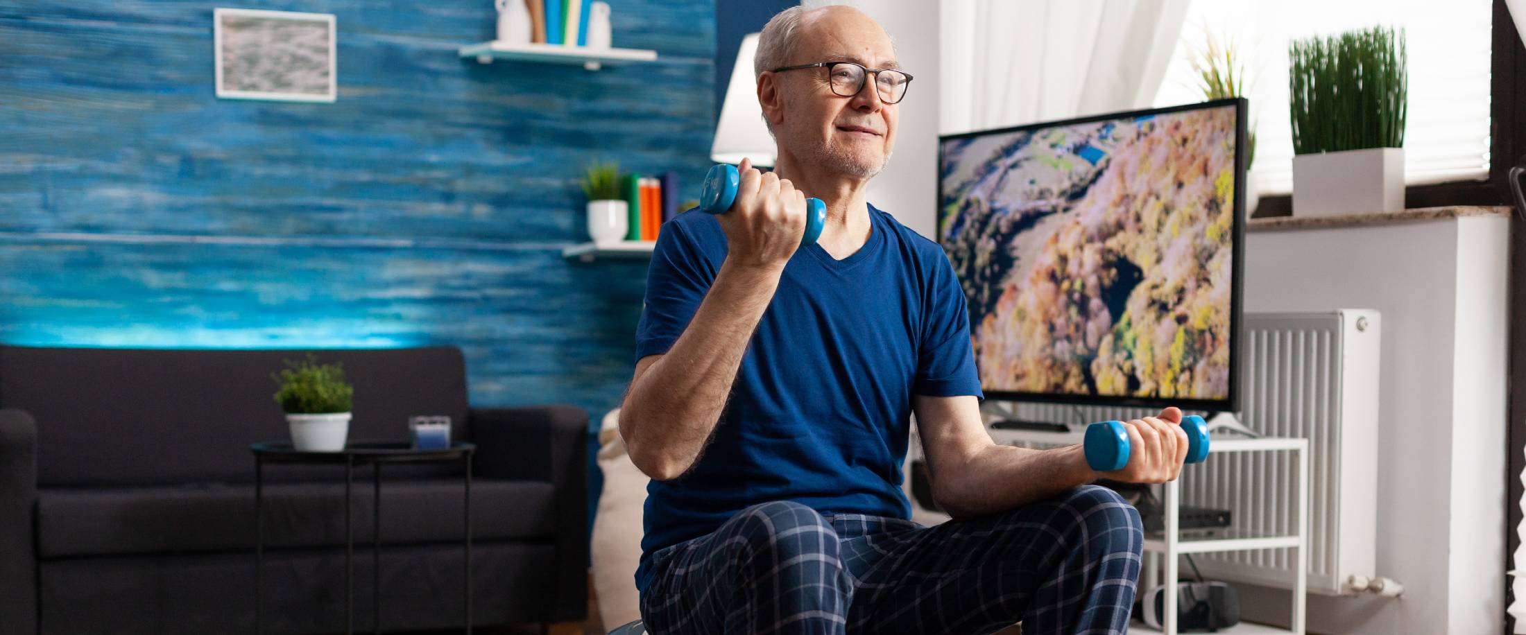 Senior man lifting weights at home