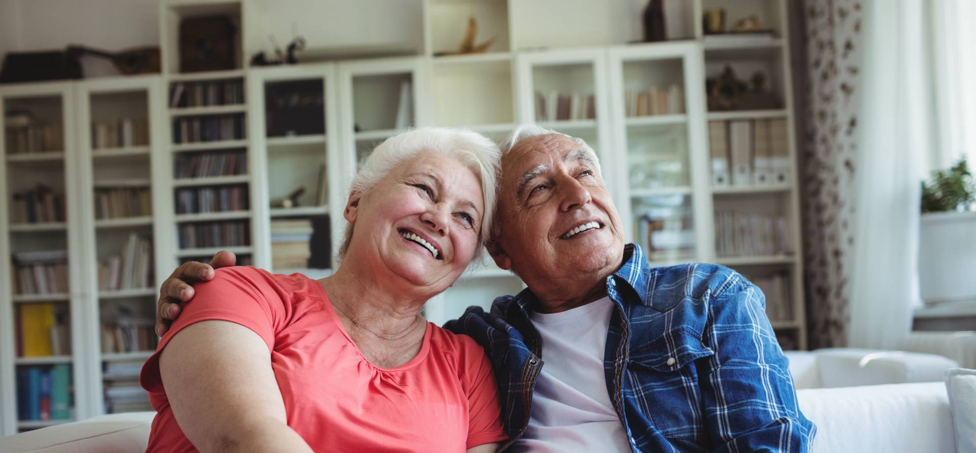 happy senior couple smiling and leaning their heads on one another