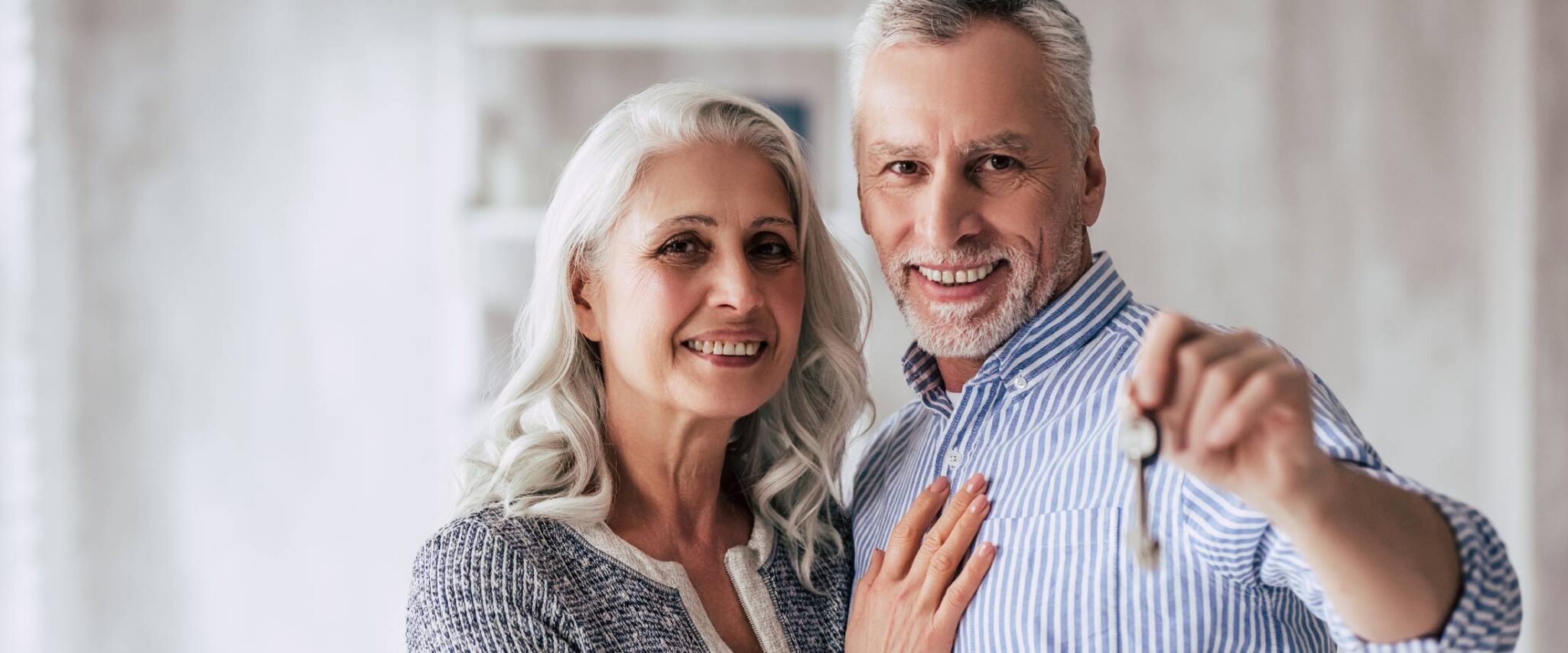 Senior couple holding up key