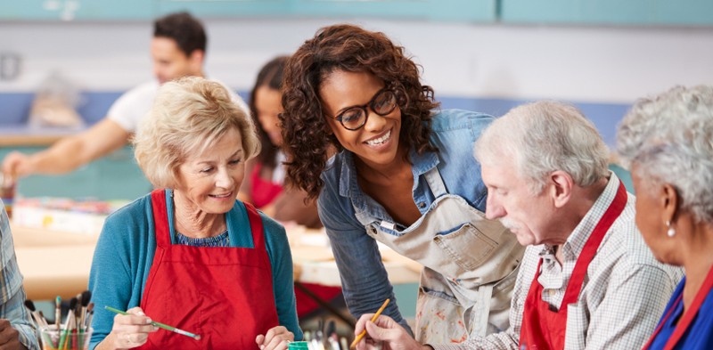 happy seniors working on arts and crafts at their retirement community