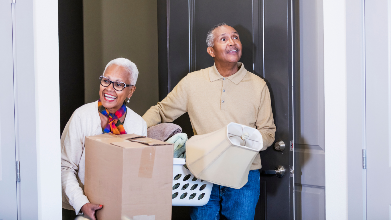 Senior couple holding moving boxes