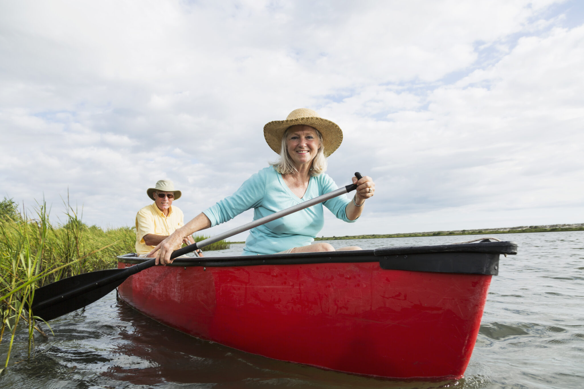 A senior woman and a senior man in a canoe in the Florida wetlands