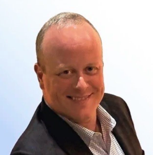 Portrait of a man in a black suit and checkered shirt