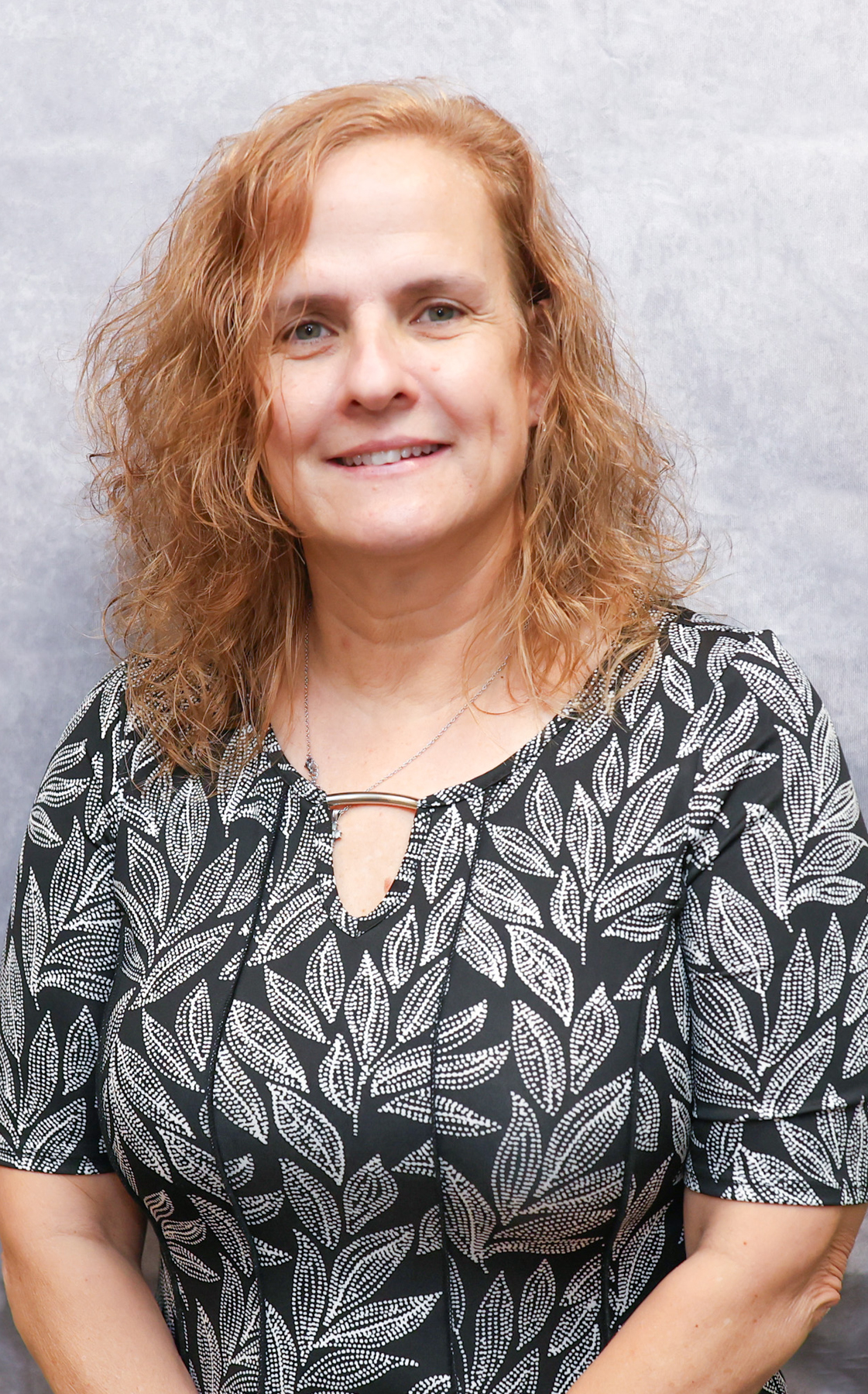 Portrait of a woman in a black and white leaf patterned blouse