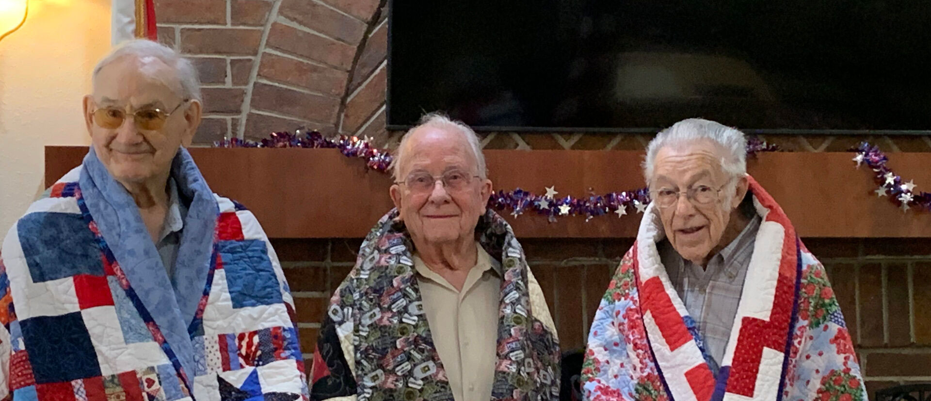 World War II veterans with their quilts